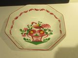 a red and white plate with flowers and birds on it