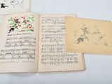 three old music books sitting on top of each other on a table