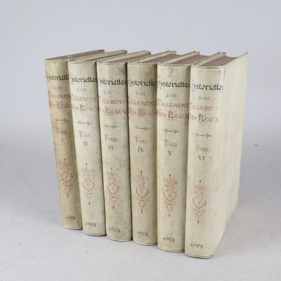 six vieux livres empilés les uns sur les autres sur une surface blanche