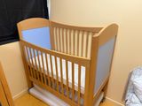 a baby crib in a small room next to a window