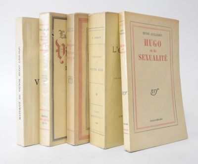several books are lined up in a row on a white surface