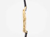 an image of a close up of a gold watch on a black strap