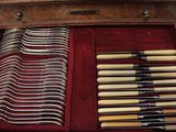many forks and knives in a case on the table