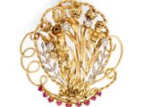 une image représentant une broche en or ornée de fleurs