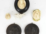un ensemble de trois médaillons sculptés en ivoire et noir sur un fond blanc