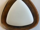 a triangle shaped mirror hanging on the wall