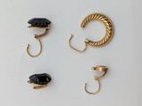 three pairs of gold and black stone earrings and a ring