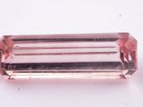 un gros plan d'une tourmaline rose posée sur une surface blanche