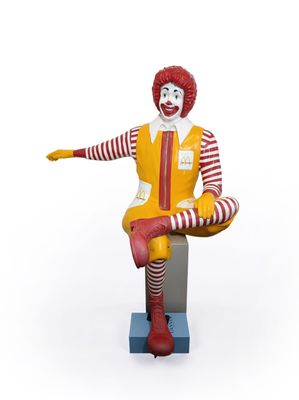 statue of ronald the clown sitting on a stool