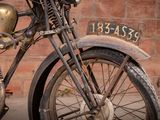 a old motorcycle that is parked in front of a brick wall