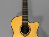 un gros plan d'une guitare acoustique sur fond gris