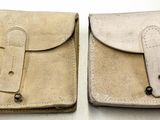 une paire de pochettes en cuir beige avec une poignée en bois, posées sur une surface blanche