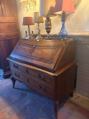 two lamps on top of a wooden desk in a room