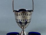 an image of a silver cup and two blue cups on a table