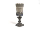 a silver cup that is sitting on top of a table