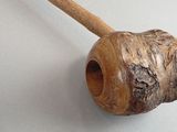 a wooden pipe with a wooden handle on a table