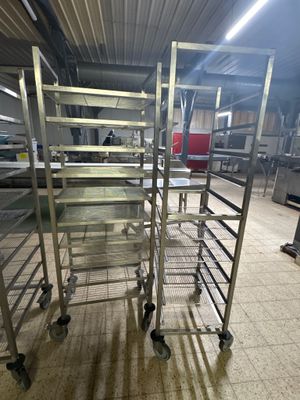 une étagère métallique sur laquelle sont posés plusieurs plateaux de nourriture