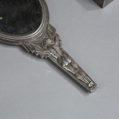 un miroir argenté posé sur une table à côté d'une boîte