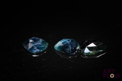 trois tourmalines bleues et vertes sur un fond noir