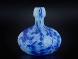 un vase en verre bleu et blanc posé sur une surface noire