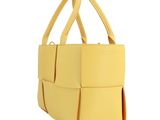 the large yellow bag is sitting on a white surface