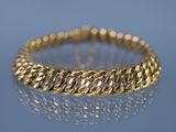 un gros plan d'un bracelet en or sur un fond bleu