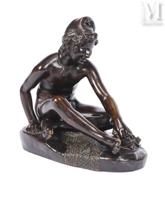 bronze statue of a boy sitting on a rock with his feet on the ground