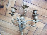 a candle holder on the floor with three birds on it