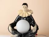 a figurine of a man sitting on a table with a ball