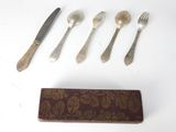 five forks, a spoon, and a knife on a table