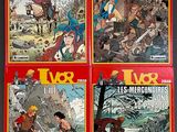 four books of comics on display on a table in a room