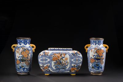 trois vases bleus et blancs posés les uns à côté des autres sur une surface noire
