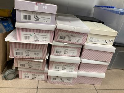 plusieurs cartons empilés les uns sur les autres sur un sol carrelé