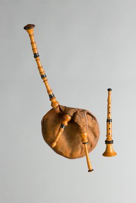 deux pipes en bois et une cornemuse accrochée au mur