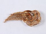an image of a gold brooch with a diamond in the center