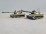 two toy tanks sitting side by side on a table