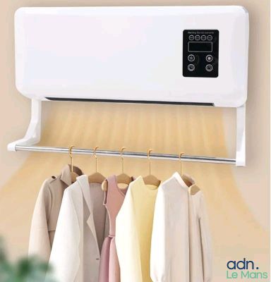 un climatiseur blanc posé sur un mur, à côté de vêtements