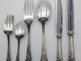 five forks, a knife, a spoon, and a knife on a table
