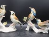 trois figurines d'oiseaux perchés sur une branche d'arbre