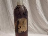 une vieille bouteille avec une étiquette, posée sur une table