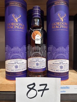 un gros plan sur trois bouteilles d'alcool posées sur une étagère