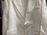 a white jacket hanging on a rack in a store