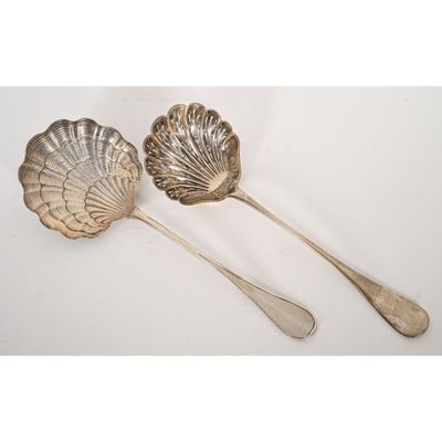 a pair of silverware spoons and a spoon with a shell shaped handle