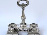 a silver candle holder with two candles on top of it