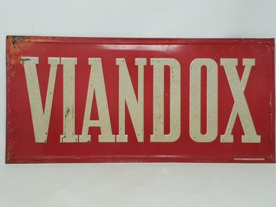 une vieille enseigne rouge et blanche sur laquelle est inscrit le mot « Vandox »