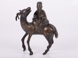 figurine en bronze représentant un homme à dos de chameau avec une chèvre