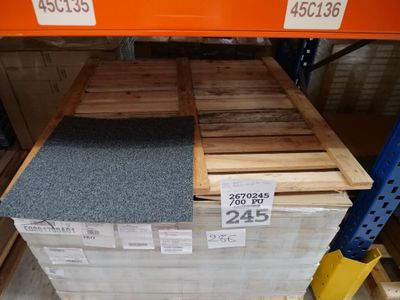 une pile de palettes en bois dans un magasin, sur lesquelles sont apposées des étiquettes de prix