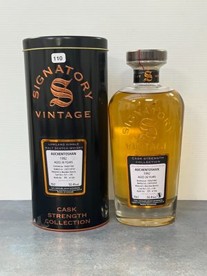 une photo d'une bouteille de whisky posée à côté d'un bidon