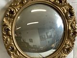 an image of a gold framed mirror sitting on top of a white sheet