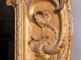 a gold mirror with a dragon on it in a room